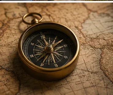 A brass compass resting on an antique map